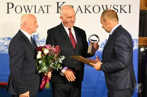 Przewodniczący i wiceprzewodniczący Rady Powiatu wręczają nagrodę Zbigniewowi Mazeli