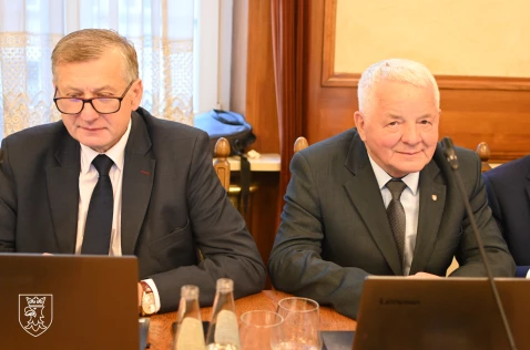 Radni Wojciech Karwat oraz Leszek Dolny siedzą w sali sesyjnej