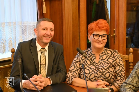 Radny Krzysztof Krupa oraz radna Beata Bartoszek siedzą w sali sesyjnej