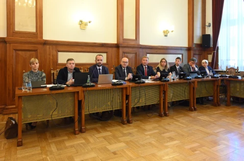 Radni Powiatu siedzą przy biurkach w sali sesyjnej