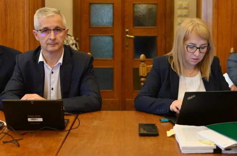 Skarbnik Powiatu Edyta Jaśnikowska i  członek Zarządu Grzegorz Stokłosa siedzą przy laptopach w sali sesyjnej
