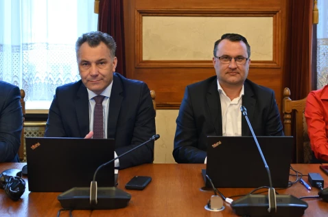 Radni Arkadiusz Wrzoszczyk i Wojciech Pałka siedzą przy laptopach w sali sesyjnej