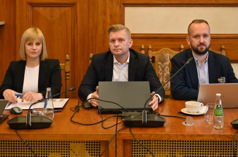 Radna Katarzyna Stadnik i radni Łukasz Krupa i Grzegorz Nędza siedzą przy laptopach w sali sesyjnej