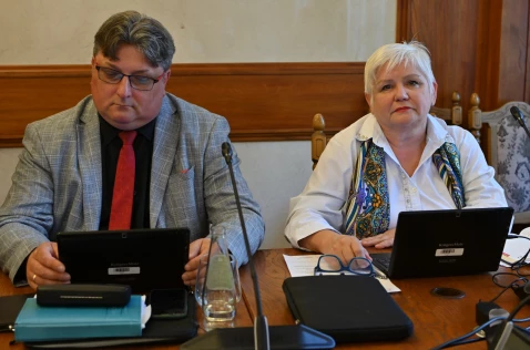 Radna Zofia Pyla i członek Zarządu Janusz Pasternak siedzą przy laptopach w sali sesyjnej.
