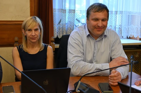 Radna Agnieszka Pyla przy laptopie i radny Adam Ślusarczyk siedzą w sali sesyjnej.