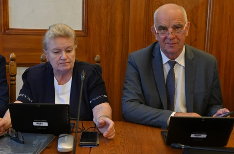Radna Wanda Kułaj i radny Piotr Goraj siedzą przy laptopach w sali sesyjnej.