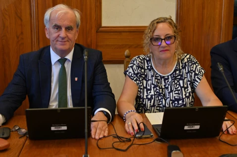 Radna Romana Maziej-Niewczas i radny Krzysztof Gębala siedzą przy laptopach w sali sesyjnej.