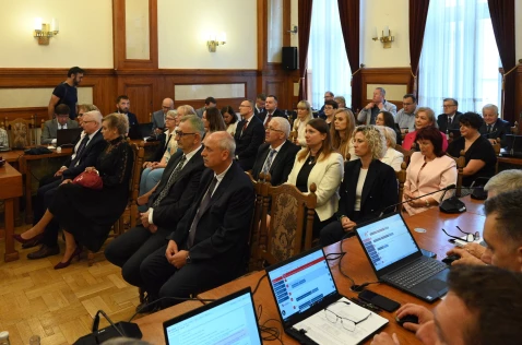 Zasłużeni pracownicy Starostwa Powiatowego w Krakowie i jednostek organizacyjnych siedzą na środku sali sesyjnej