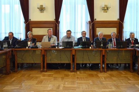 Radni Powiatu siedzą przy biurkach na sali sesyjnej