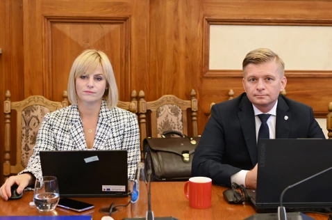 Radna Katarzyna Stadnik i radny Łukasz Krupa siedzą przy laptopach w sali sesyjnej