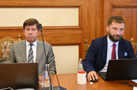Radni Marian Janicki i Grzegorz Małodobry siedzą w sali sesyjnej przy laptopach
