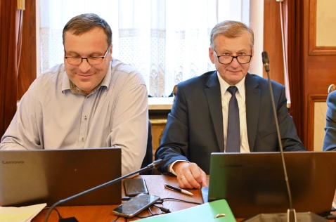 Radni Adam Ślusarczyk i Wojciech Karwat siedzą w sali sesyjnej przy laptopach