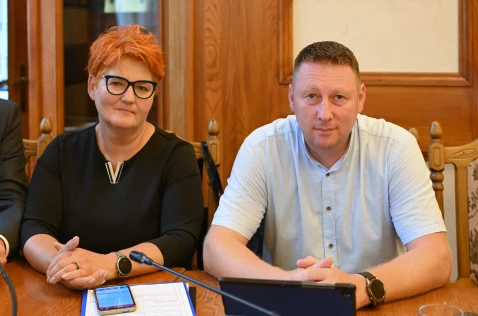Radna Beata Bartoszek oraz radny Rafał Szczypczyk siedzą w sali sesyjnej